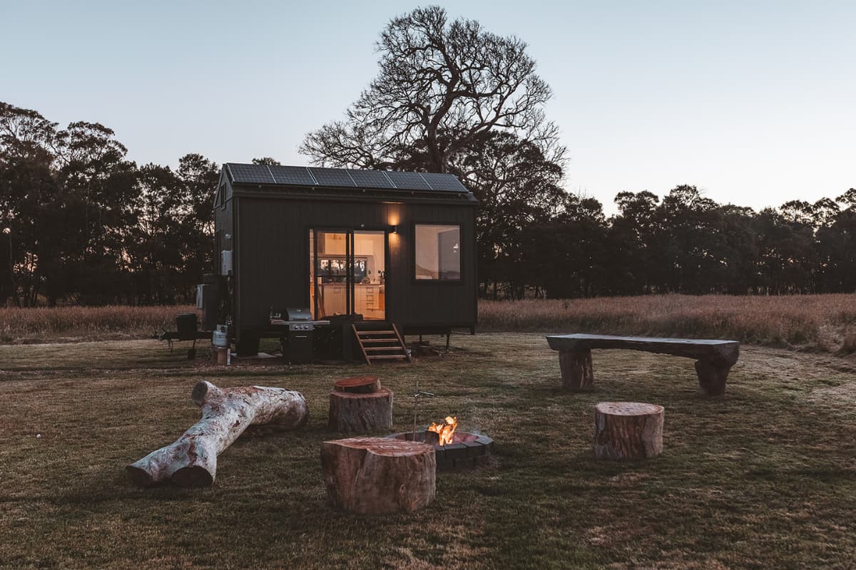 Tiny house in Victoria's Grampians region at night with a campfire.