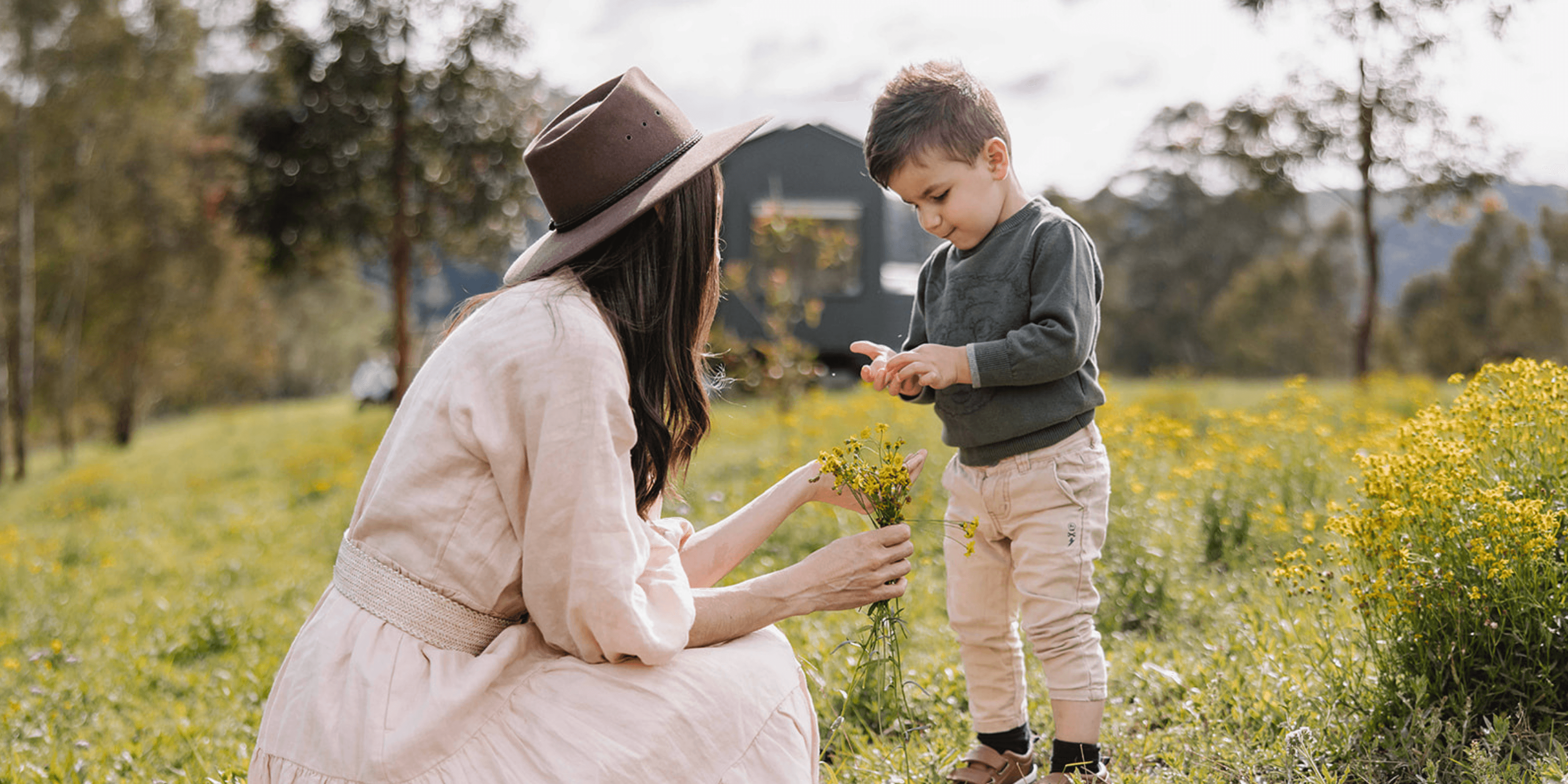 Mother and son enjoying a slow morning outside a tiny home in the Australian wilderness.