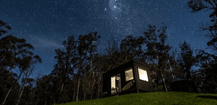 Tiny house at night with a starry sky as the backdrop.